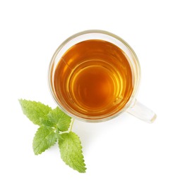 Photo of Aromatic lemon balm tea in glass cup and fresh leaves isolated on white, top view
