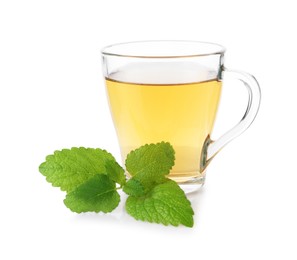 Photo of Aromatic lemon balm tea in glass cup and fresh leaves isolated on white