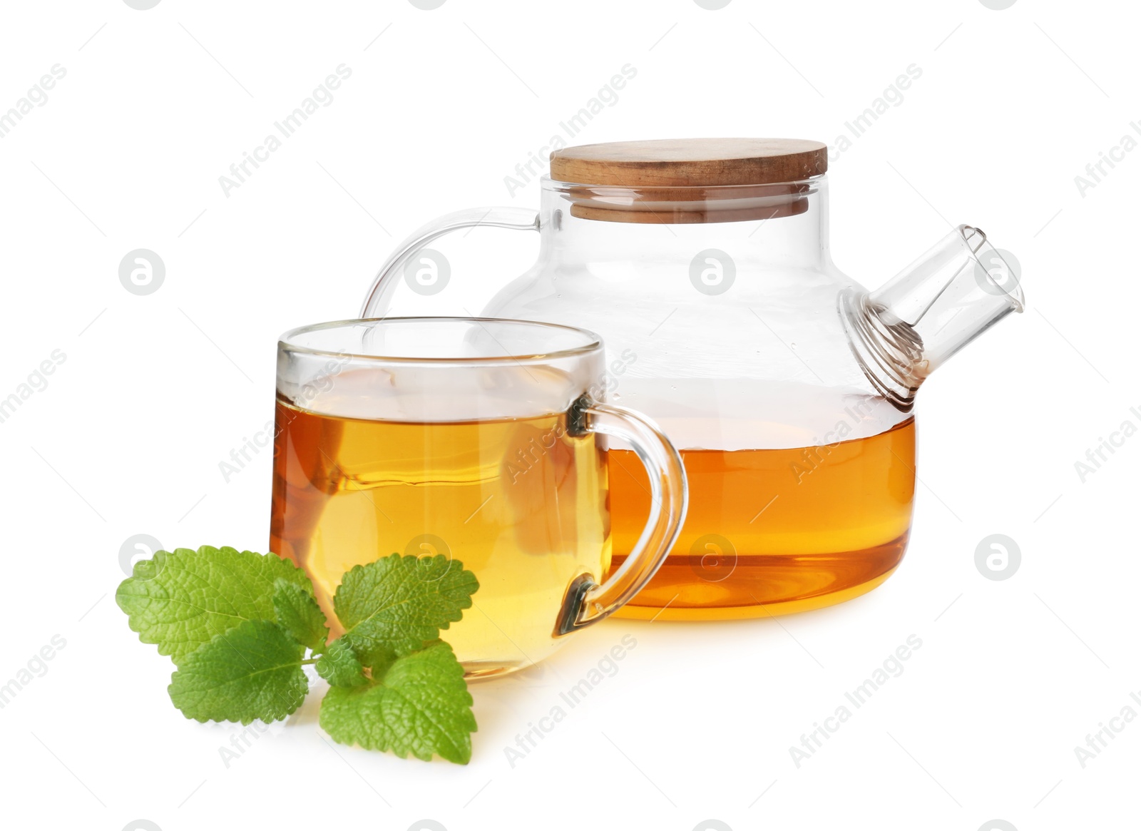 Aromatic lemon balm tea in glass cup, teapot and fresh leaves isolated on white Photo of Aromatic lemon balm tea in glass cup, teapot and fresh leaves isolated on white