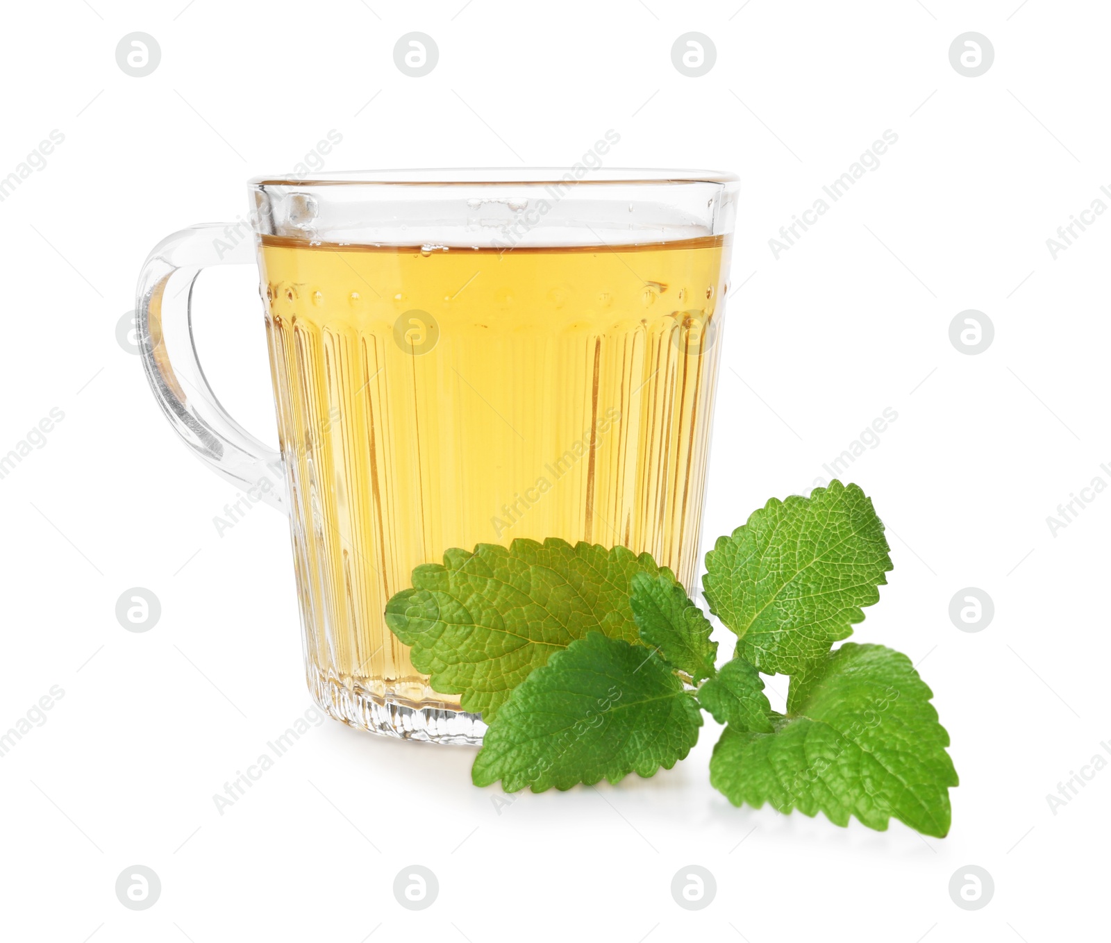 Aromatic lemon balm tea in glass cup and fresh leaves isolated on white Photo of Aromatic lemon balm tea in glass cup and fresh leaves isolated on white