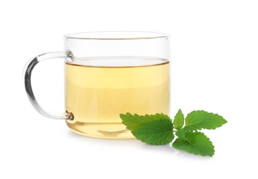 Photo of Aromatic lemon balm tea in glass cup and fresh leaves isolated on white