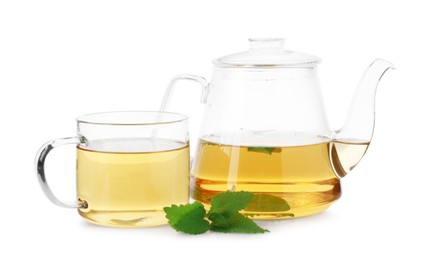 Photo of Aromatic lemon balm tea in glass cup, teapot and fresh leaves isolated on white