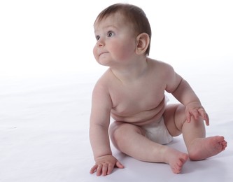 Photo of Cute little baby in diaper sitting on white background