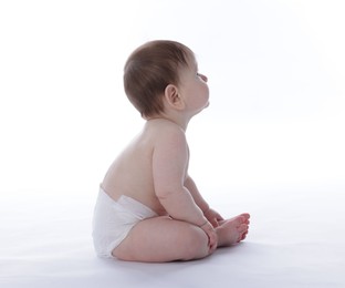 Photo of Cute little baby in diaper sitting on white background