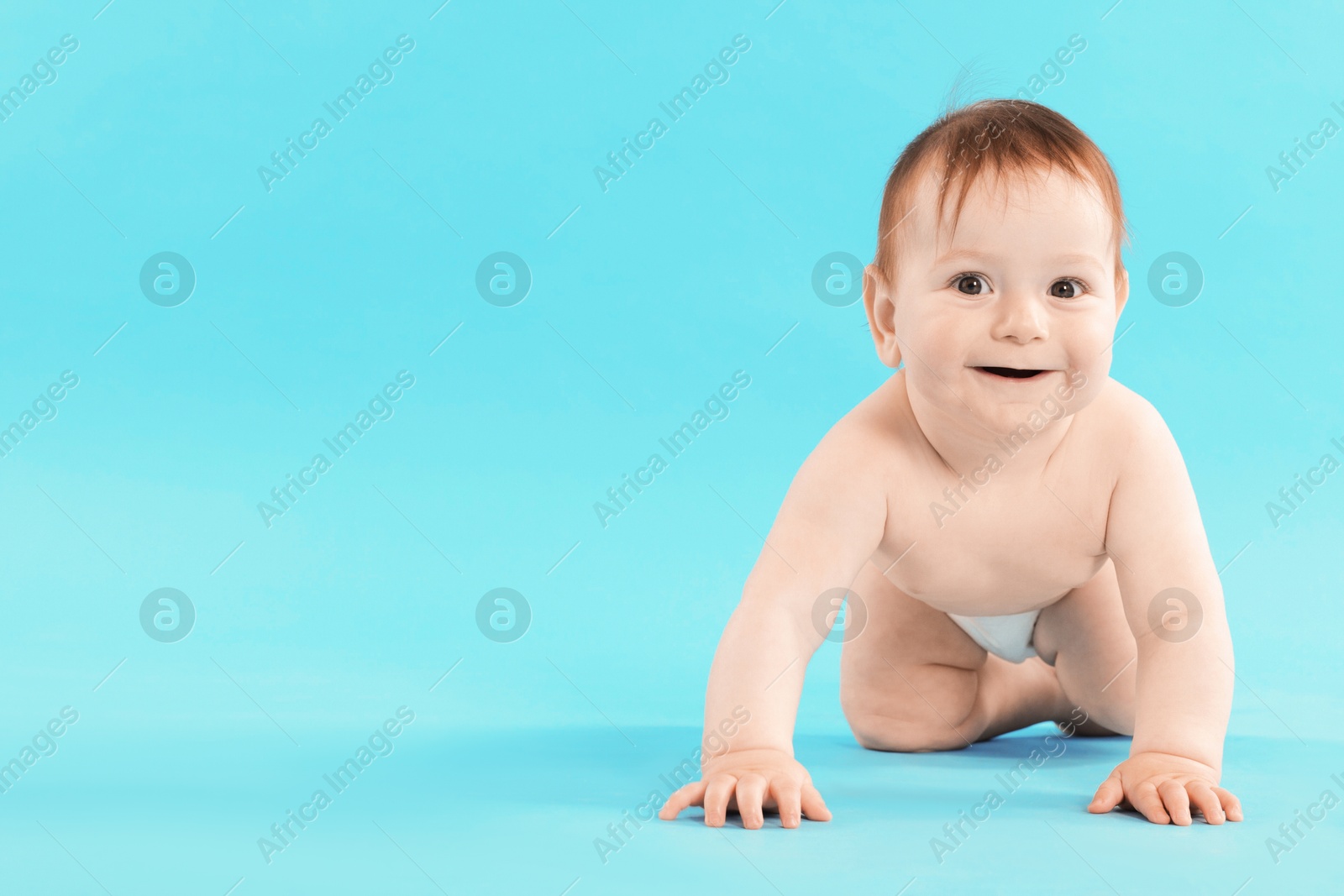 Cute little baby crawling on light blue background. Space for text Photo of Cute little baby crawling on light blue background. Space for text
