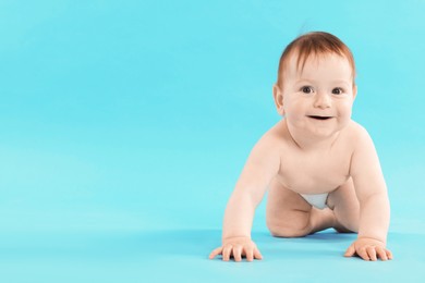 Photo of Cute little baby crawling on light blue background. Space for text