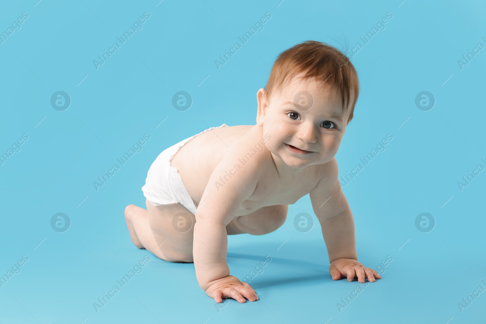 Cute little baby crawling on light blue background Photo of Cute little baby crawling on light blue background