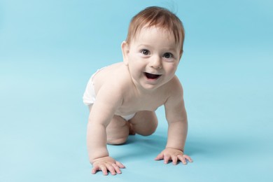 Photo of Cute little baby crawling on light blue background