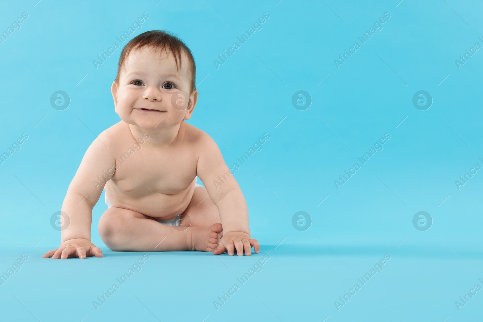 Cute little baby crawling on light blue background. Space for text Photo of Cute little baby crawling on light blue background. Space for text