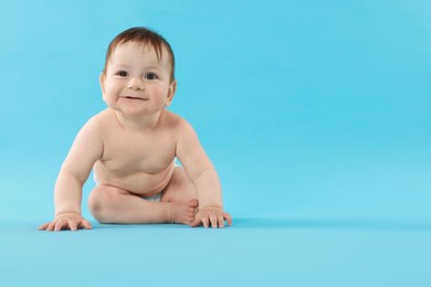Photo of Cute little baby crawling on light blue background. Space for text