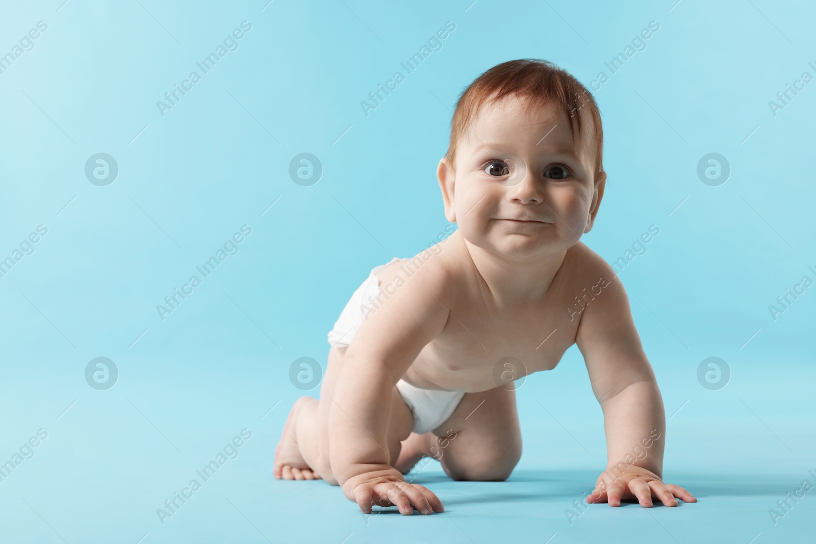 Cute little baby crawling on light blue background. Space for text Photo of Cute little baby crawling on light blue background. Space for text