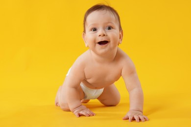 Photo of Cute little baby crawling on yellow background