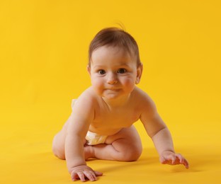 Photo of Cute little baby crawling on yellow background