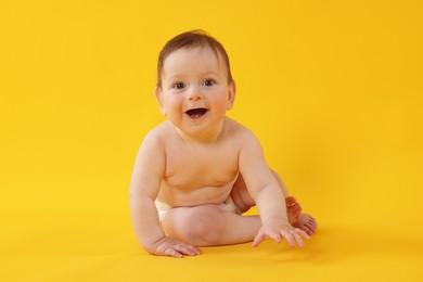 Photo of Cute little baby sitting on yellow background