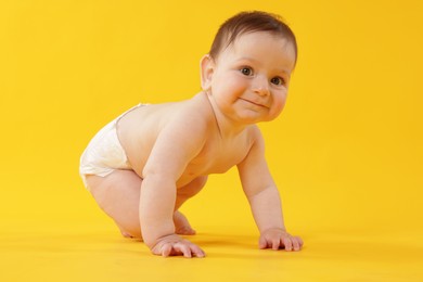 Photo of Cute little baby crawling on yellow background