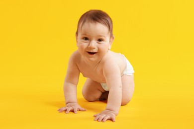 Photo of Cute little baby crawling on yellow background