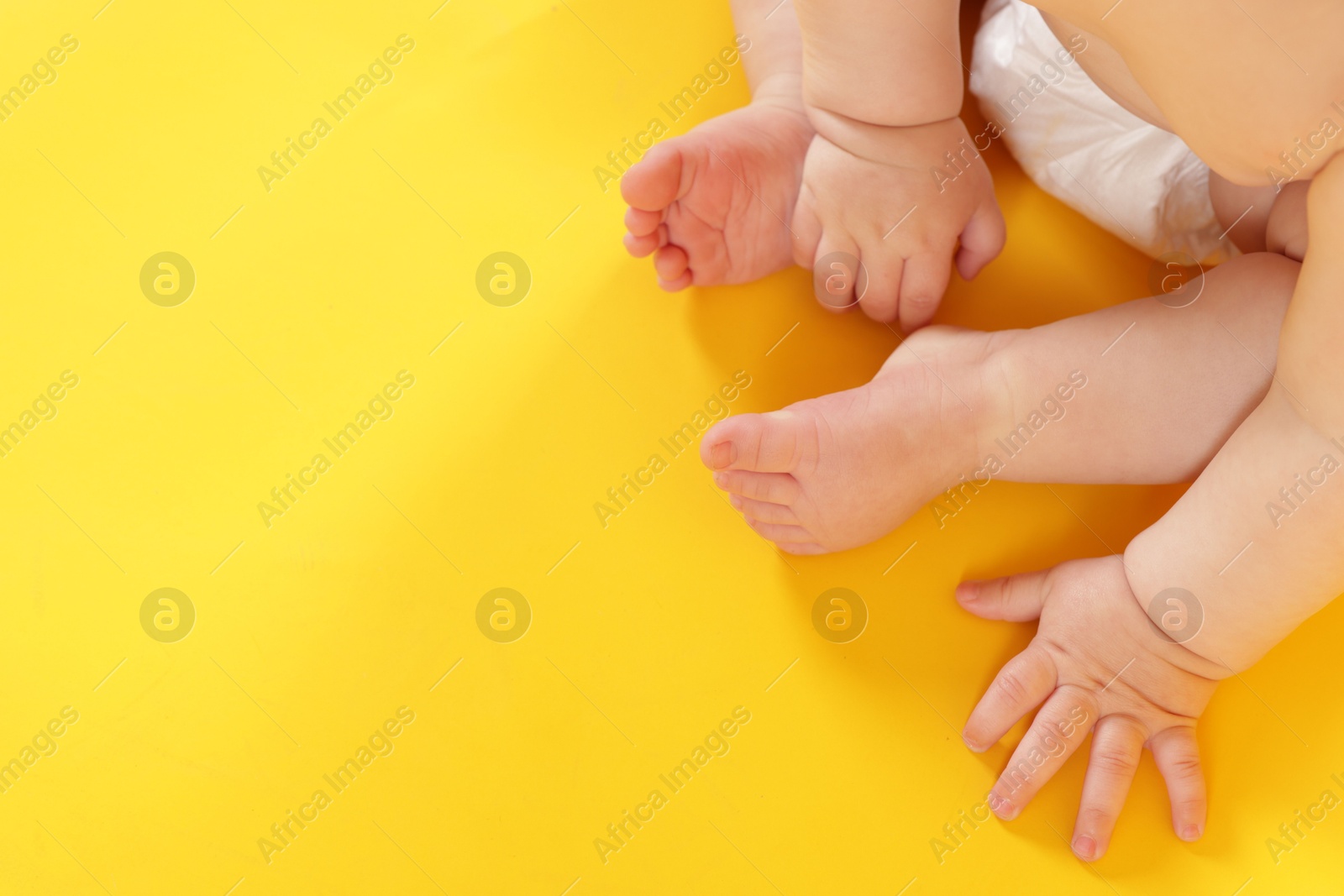 Cute little baby in diaper on yellow background, above view. Space for text Photo of Cute little baby in diaper on yellow background, above view. Space for text