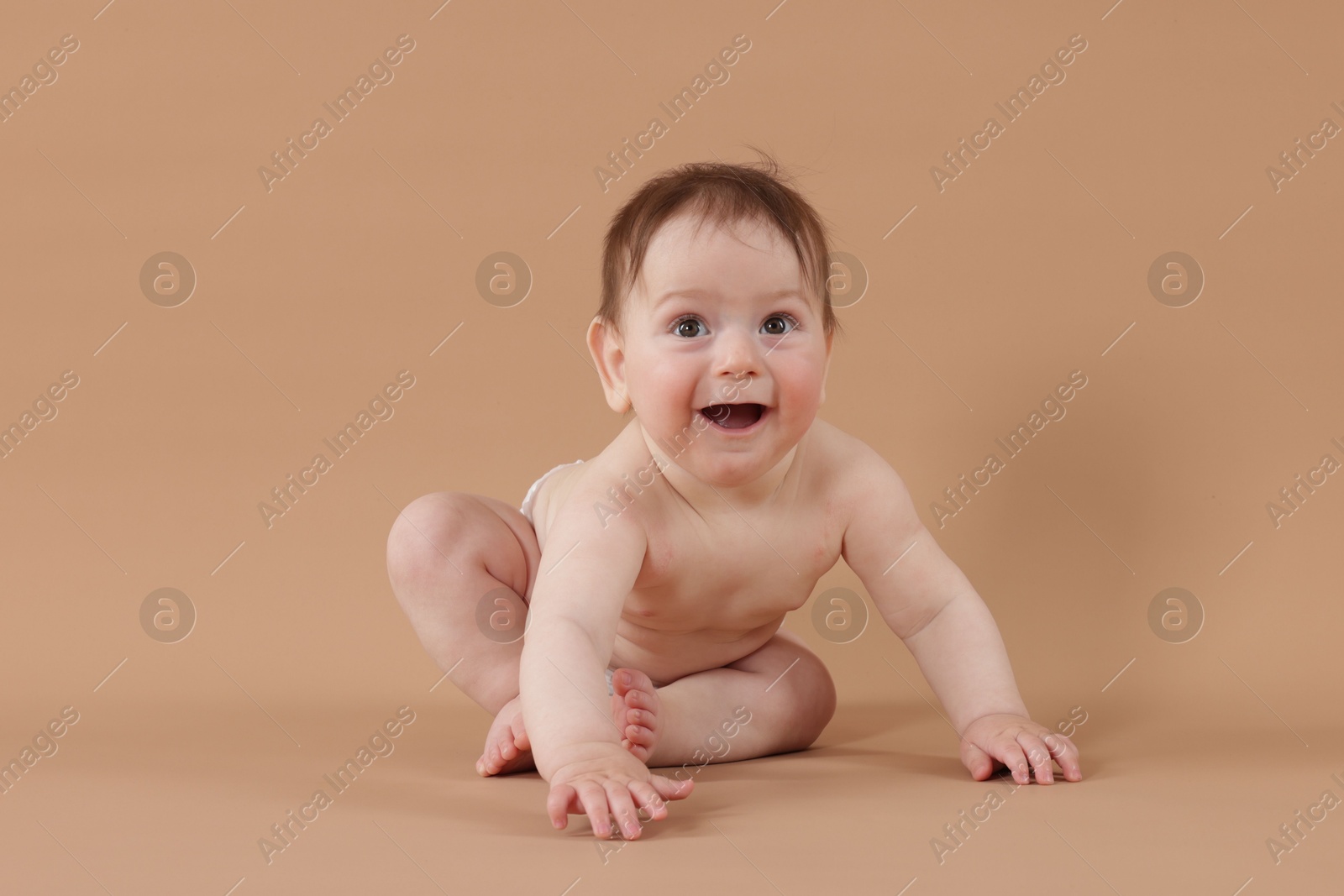Cute little baby crawling on beige background Photo of Cute little baby crawling on beige background
