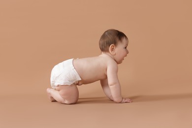 Photo of Cute little baby crawling on beige background