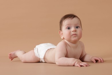 Photo of Cute little baby crawling on beige background
