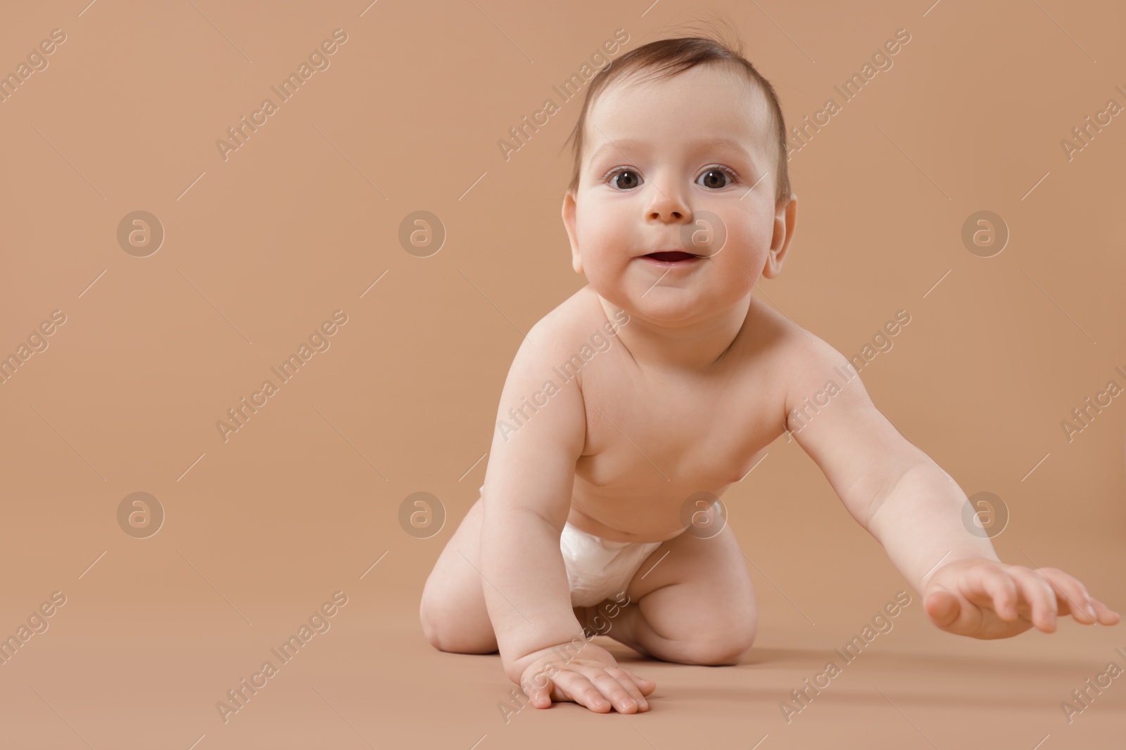 Cute little baby crawling on beige background. Space for text Photo of Cute little baby crawling on beige background. Space for text