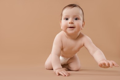 Photo of Cute little baby crawling on beige background. Space for text