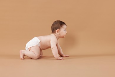 Photo of Cute little baby crawling on beige background