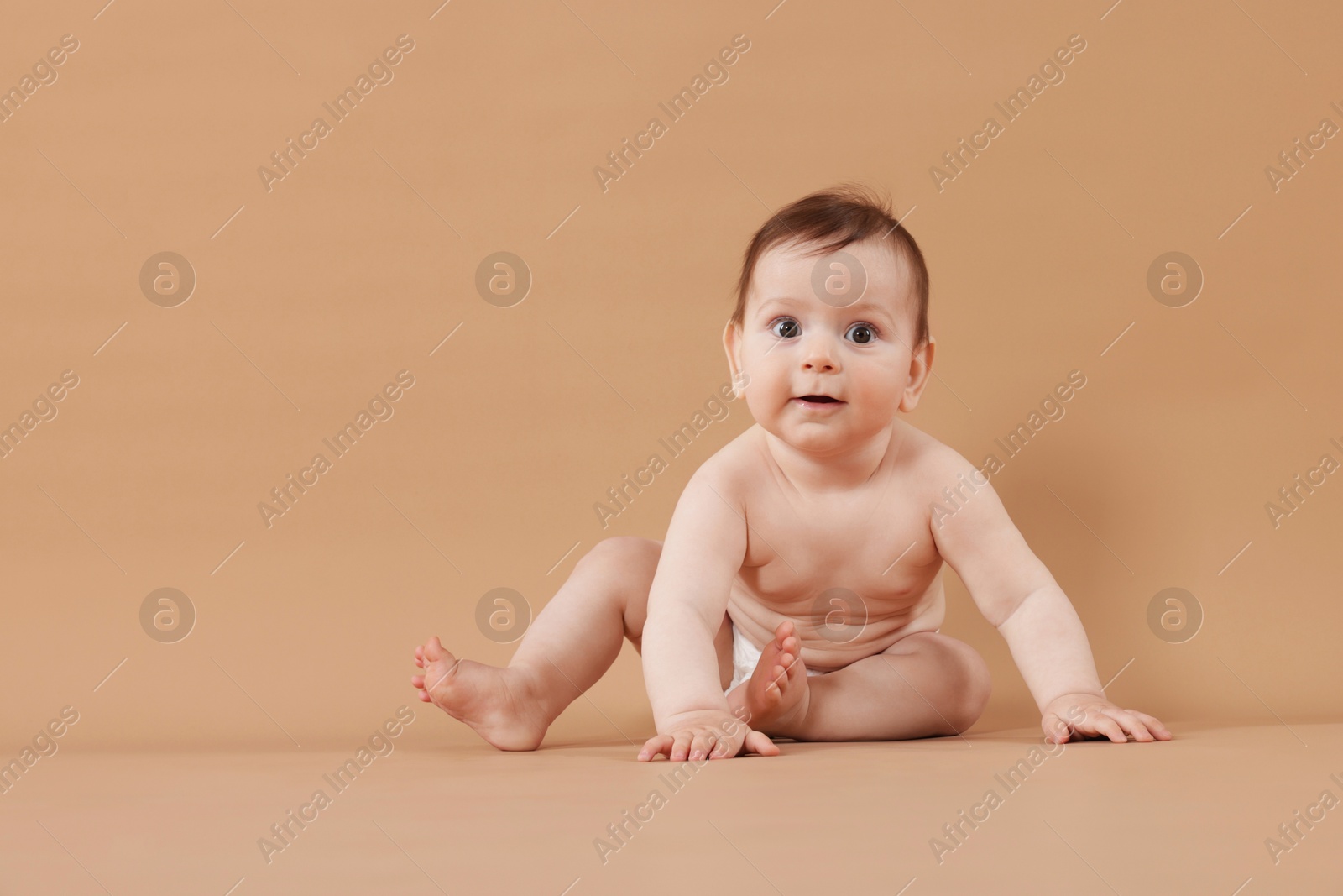 Cute little baby in diaper sitting on beige background. Space for text Photo of Cute little baby in diaper sitting on beige background. Space for text