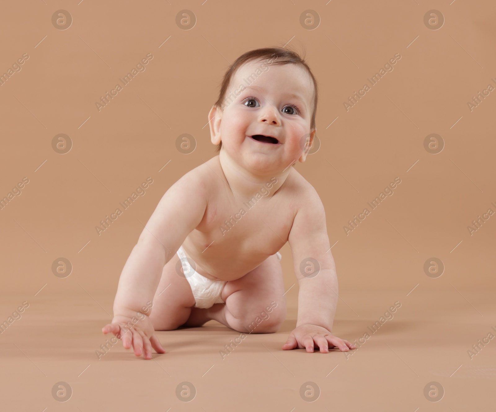 Cute little baby crawling on beige background Photo of Cute little baby crawling on beige background
