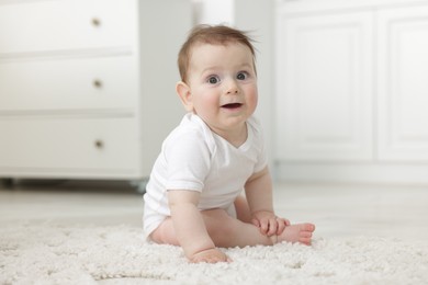 Photo of Cute little baby crawling on floor at home