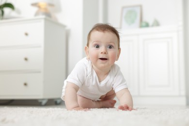 Photo of Cute little baby crawling on floor at home