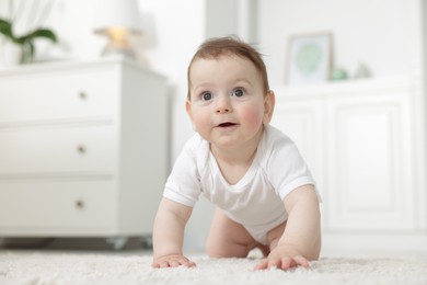 Photo of Cute little baby crawling on floor at home