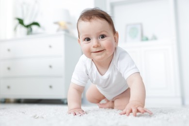 Photo of Cute little baby crawling on floor at home