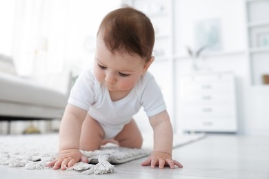 Photo of Cute little baby crawling on floor at home