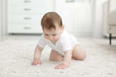 Photo of Cute little baby crawling on floor at home