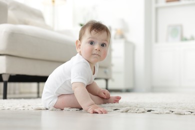 Photo of Cute little baby crawling on floor at home
