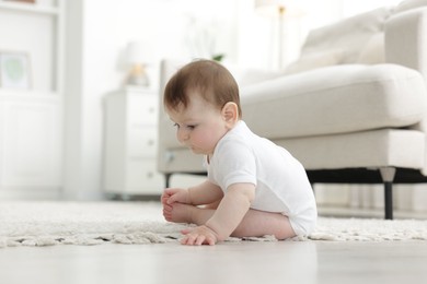 Photo of Cute little baby crawling on floor at home