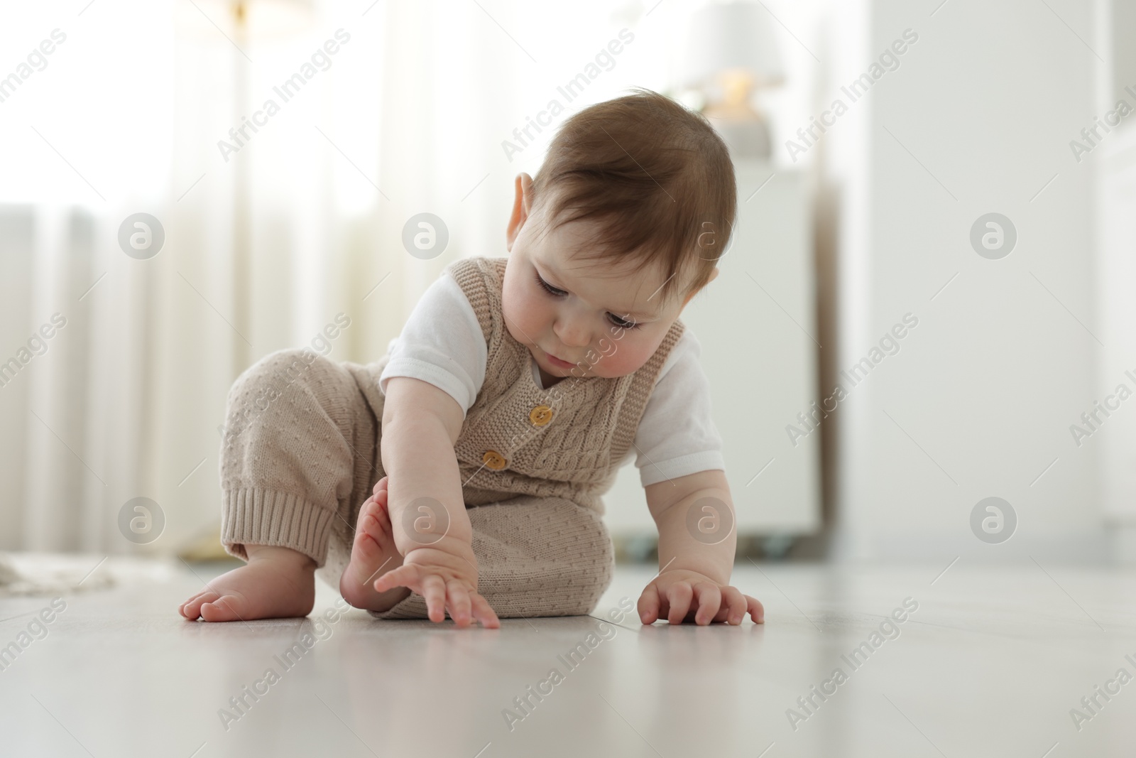 Cute little baby crawling on floor at home Photo of Cute little baby crawling on floor at home