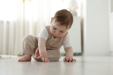 Photo of Cute little baby crawling on floor at home