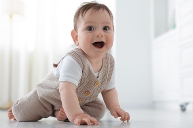 Photo of Cute little baby crawling on floor at home