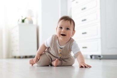 Photo of Cute little baby crawling on floor at home