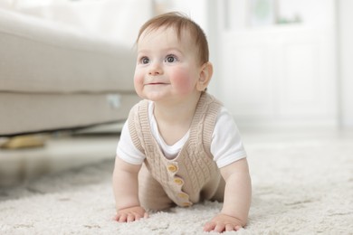 Photo of Cute little baby crawling on floor at home
