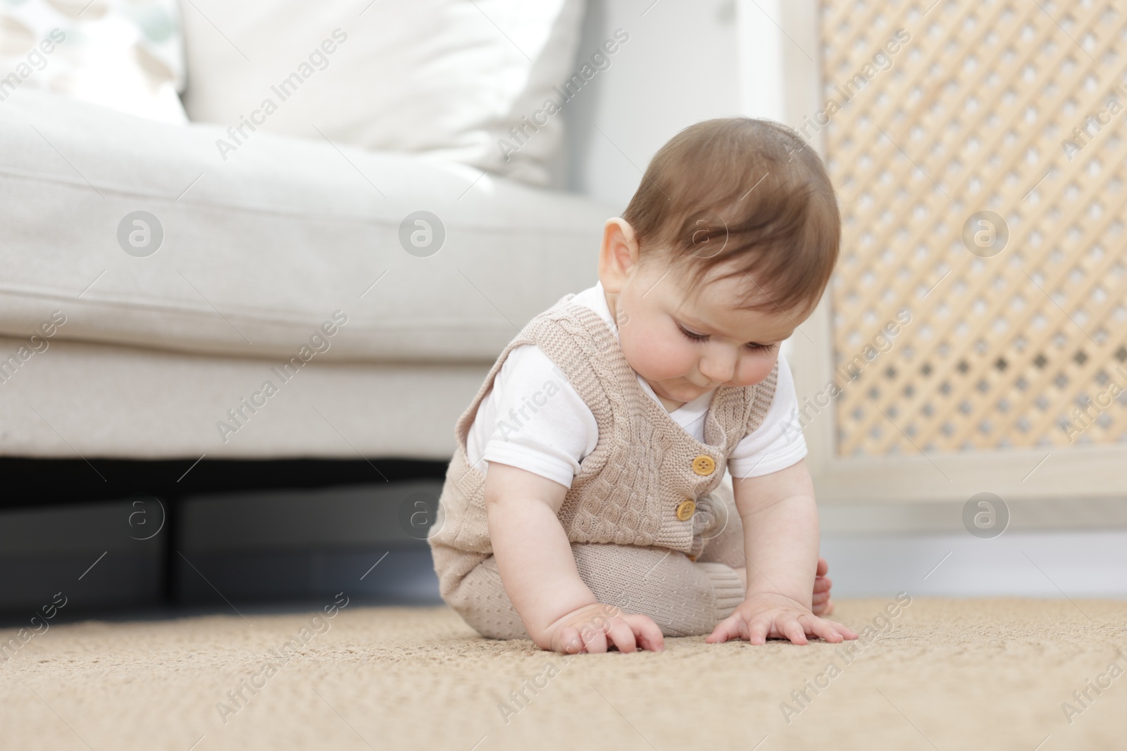 Cute little baby sitting on floor at home Photo of Cute little baby sitting on floor at home