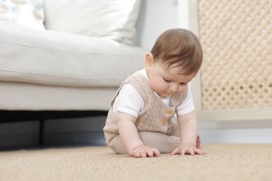 Photo of Cute little baby sitting on floor at home