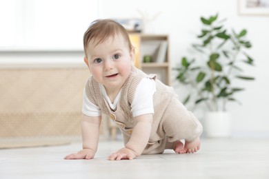 Photo of Cute little baby crawling on floor at home