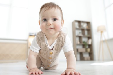 Photo of Cute little baby crawling on floor at home