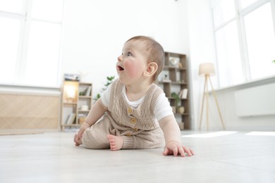 Photo of Cute little baby crawling on floor at home