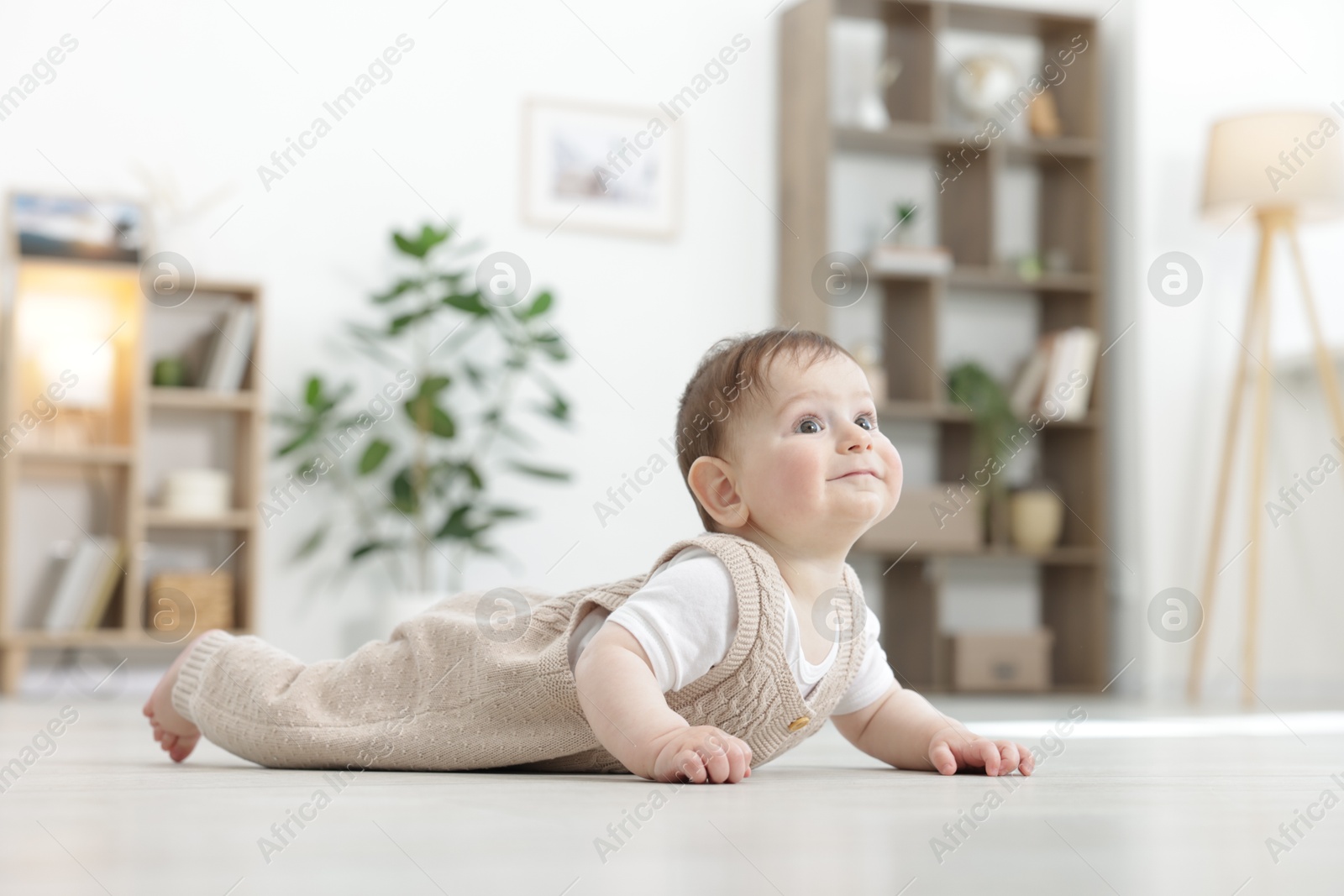 Cute little baby crawling on floor at home. Space for text Photo of Cute little baby crawling on floor at home. Space for text