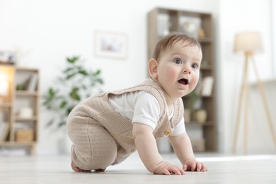 Photo of Cute little baby crawling on floor at home