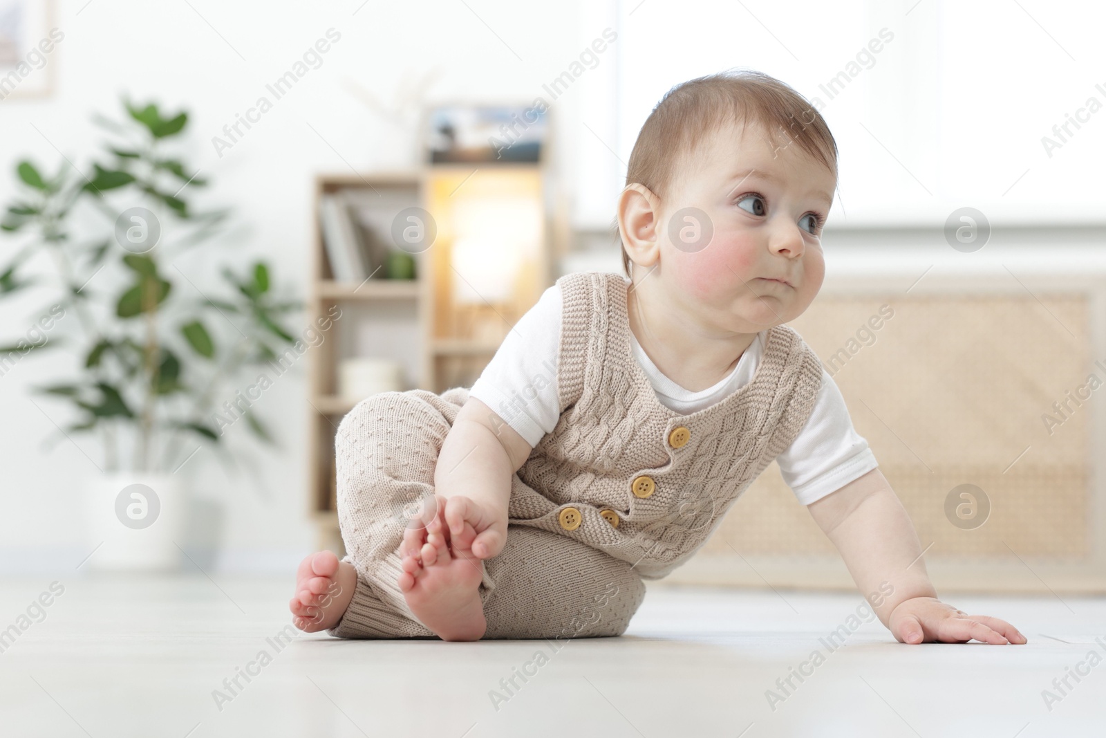 Cute little baby crawling on floor at home Photo of Cute little baby crawling on floor at home